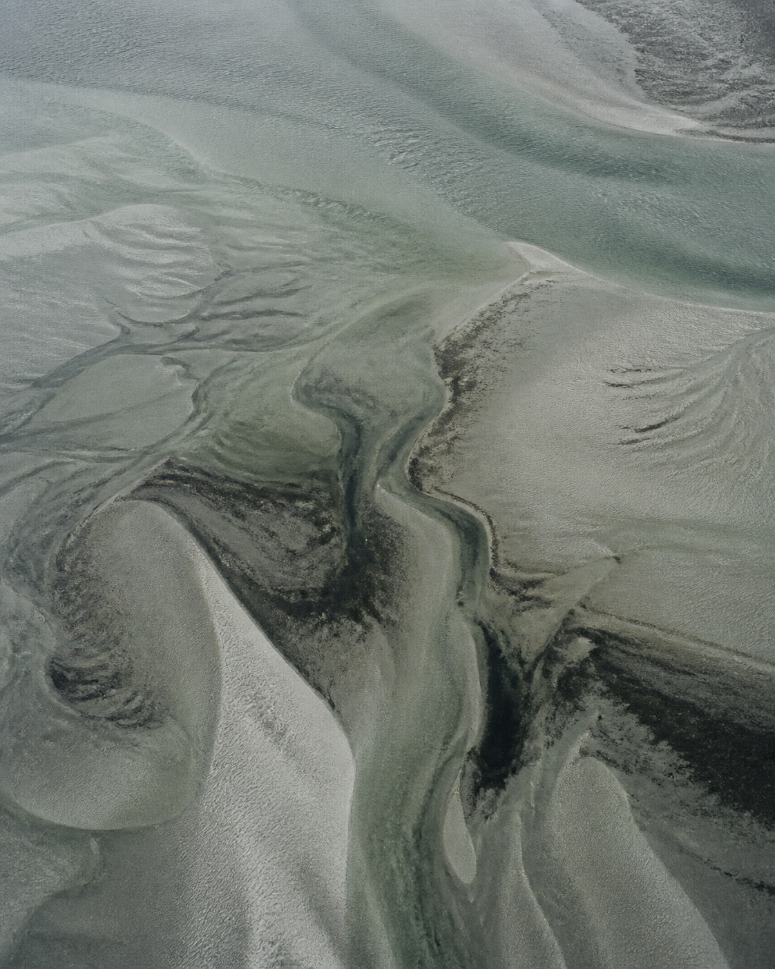 Aerial view of tidal flats and shallow water.